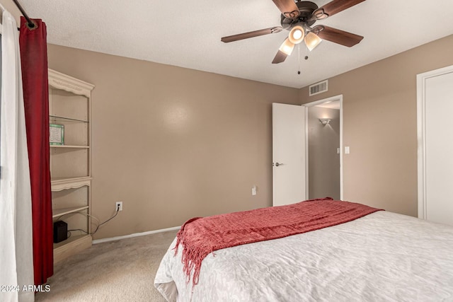 carpeted bedroom featuring a textured ceiling and ceiling fan