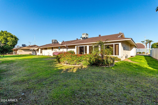 back of house with a yard and central AC unit