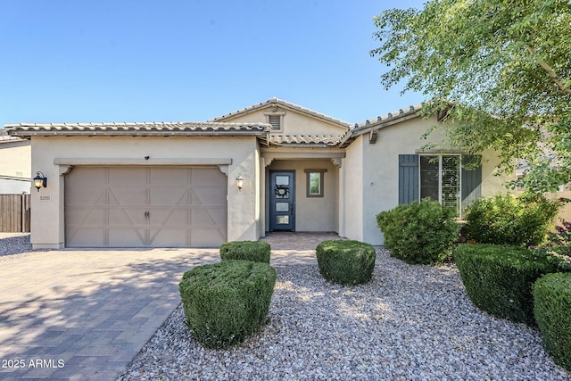 mediterranean / spanish-style home featuring stucco siding, a garage, and driveway