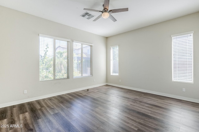 empty room with ceiling fan, dark wood-style floors, and baseboards