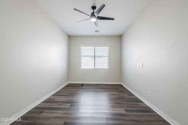 unfurnished room featuring dark wood-type flooring, a ceiling fan, and baseboards
