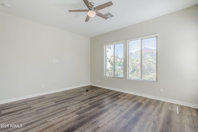 empty room featuring a ceiling fan, wood finished floors, baseboards, and a smoke detector