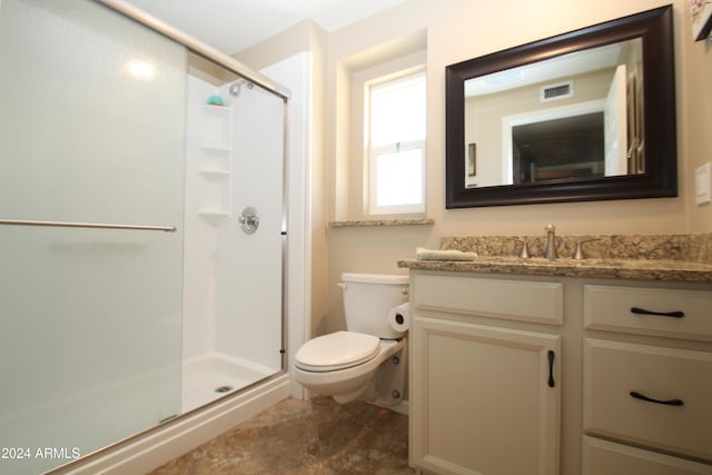 bathroom featuring vanity, toilet, and an enclosed shower