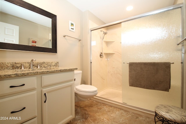 bathroom with vanity, tile patterned floors, toilet, and walk in shower