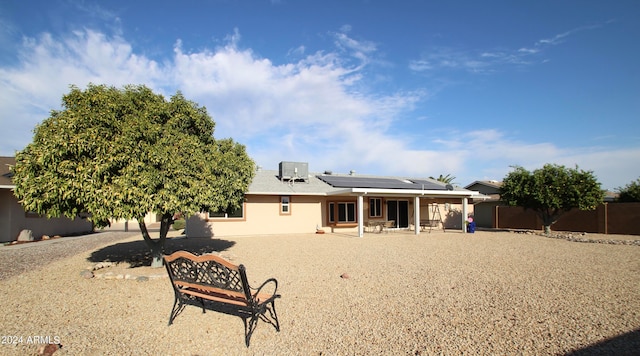 back of property featuring a patio area, solar panels, and central AC unit