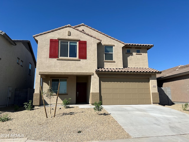 view of front of property with driveway, an attached garage, a tile roof, and stucco siding