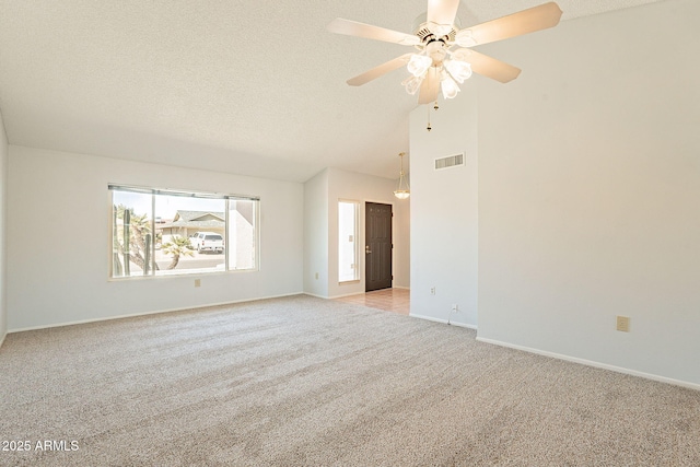 carpeted spare room featuring ceiling fan, lofted ceiling, and a textured ceiling