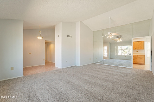 unfurnished room with ceiling fan, light carpet, a textured ceiling, and high vaulted ceiling