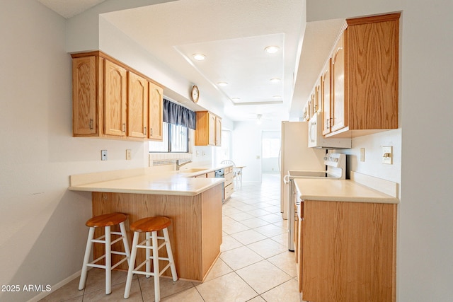 kitchen with electric stove, light tile patterned floors, kitchen peninsula, and a kitchen bar