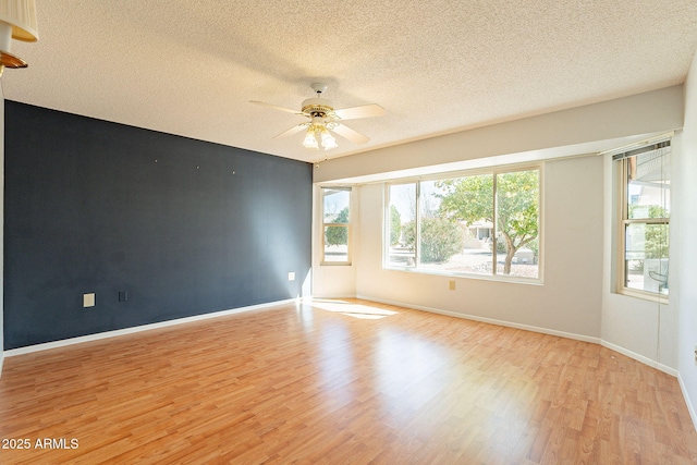 empty room featuring a textured ceiling, light hardwood / wood-style flooring, and ceiling fan