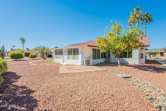 rear view of house featuring ac unit, a patio, and solar panels