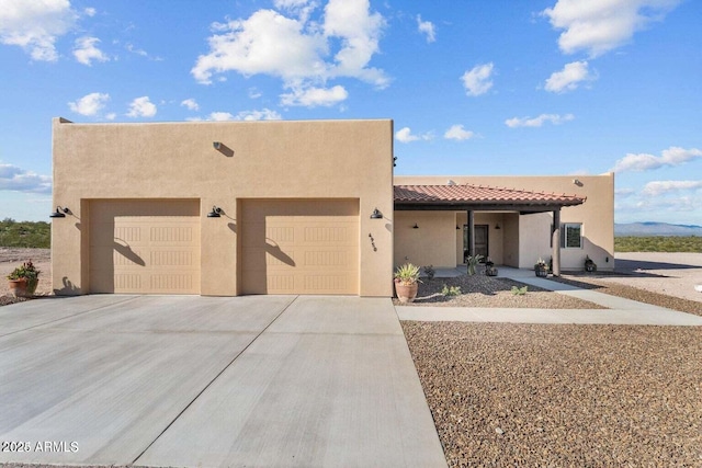 pueblo-style home featuring a garage