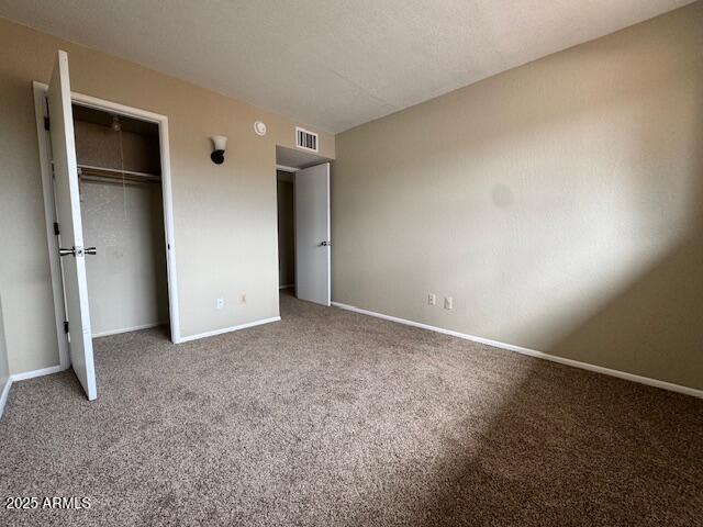 unfurnished bedroom with carpet and a closet