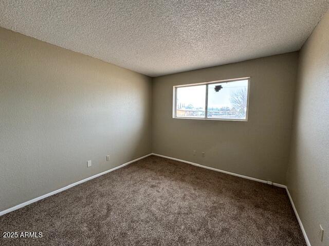 carpeted spare room featuring a textured ceiling