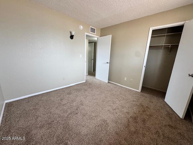 unfurnished bedroom with carpet floors, a closet, and a textured ceiling