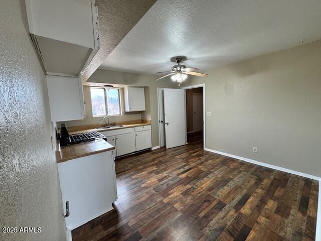 kitchen with dark wood-type flooring, sink, white cabinetry, a textured ceiling, and ceiling fan