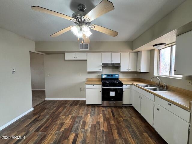 kitchen featuring white cabinetry, dark hardwood / wood-style flooring, stainless steel gas range, and sink