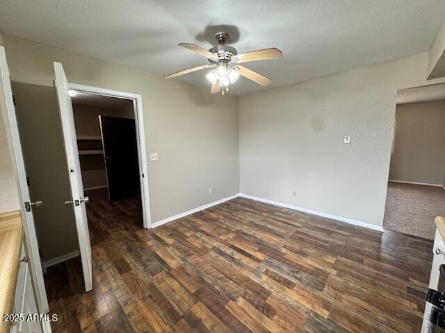 unfurnished room with ceiling fan and dark hardwood / wood-style flooring