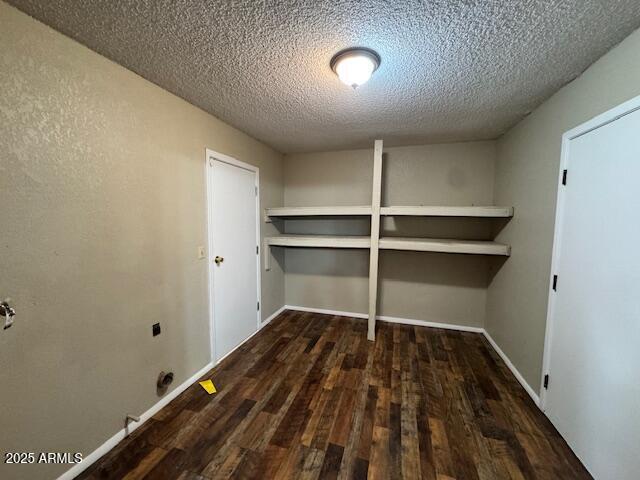 laundry area featuring dark hardwood / wood-style flooring, electric dryer hookup, and a textured ceiling