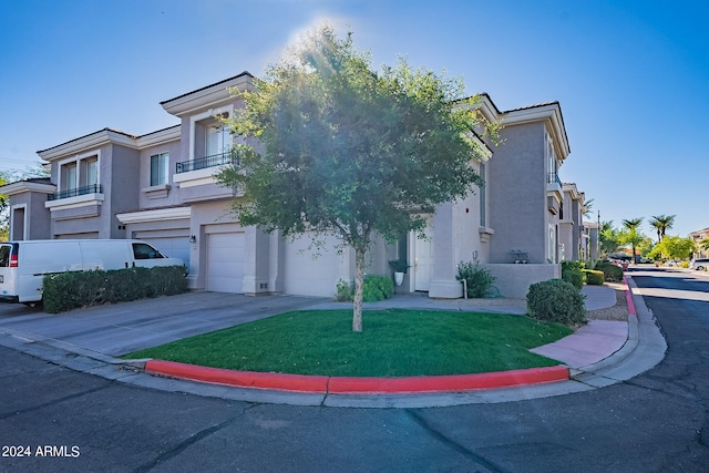 view of front of house featuring a front yard, a garage, and a balcony