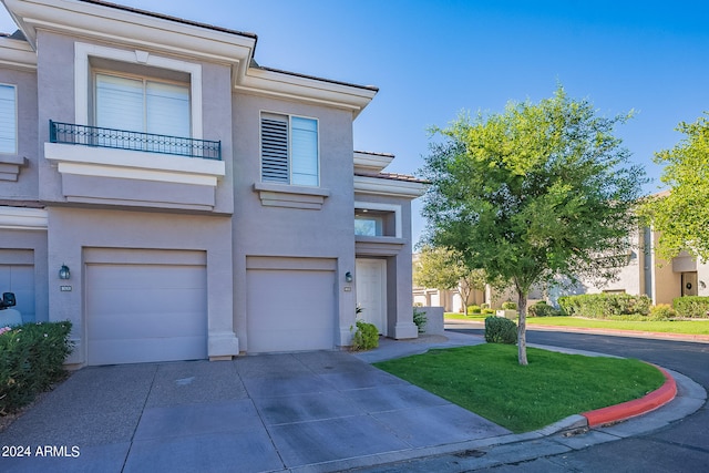 view of front of property with a front lawn, a garage, and a balcony