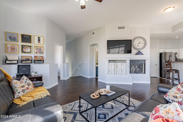 living room featuring dark wood-type flooring and ceiling fan