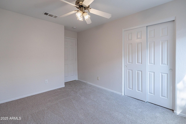 unfurnished bedroom featuring ceiling fan, a closet, and light carpet