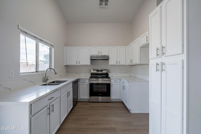 kitchen featuring dishwasher, wood-type flooring, sink, white cabinetry, and stainless steel range with electric stovetop