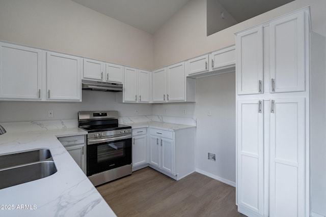 kitchen with light stone countertops, white cabinets, light hardwood / wood-style floors, sink, and stainless steel range with electric stovetop