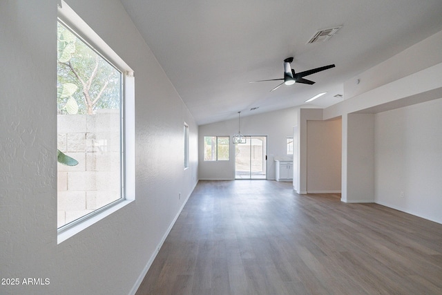 unfurnished living room featuring vaulted ceiling, ceiling fan with notable chandelier, and hardwood / wood-style floors