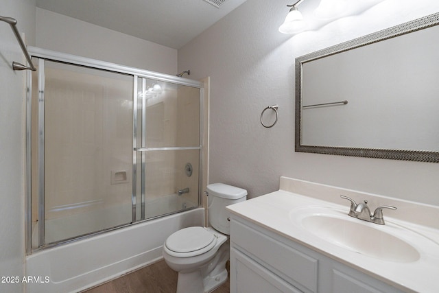 full bathroom featuring toilet, vanity, wood-type flooring, and shower / bath combination with glass door