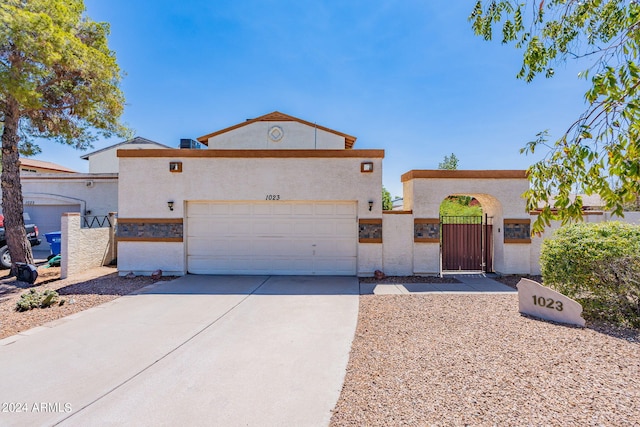 view of front of property with stucco siding, a fenced front yard, a gate, driveway, and an attached garage