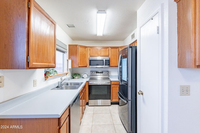 kitchen with light tile patterned floors, a sink, visible vents, light countertops, and appliances with stainless steel finishes