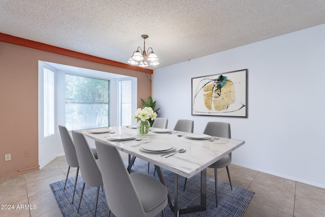 dining space featuring a notable chandelier, a textured ceiling, baseboards, and light tile patterned floors