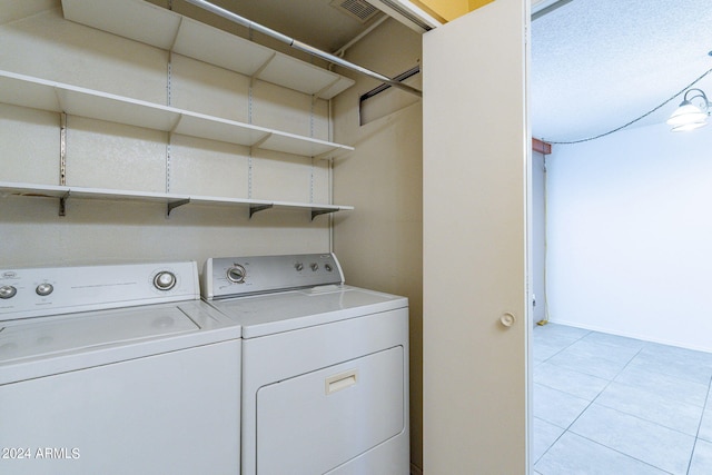 laundry room featuring laundry area, separate washer and dryer, light tile patterned flooring, and visible vents