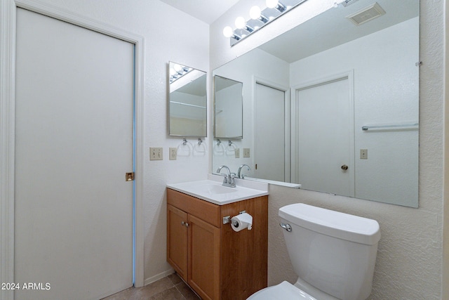 bathroom featuring toilet, visible vents, and vanity