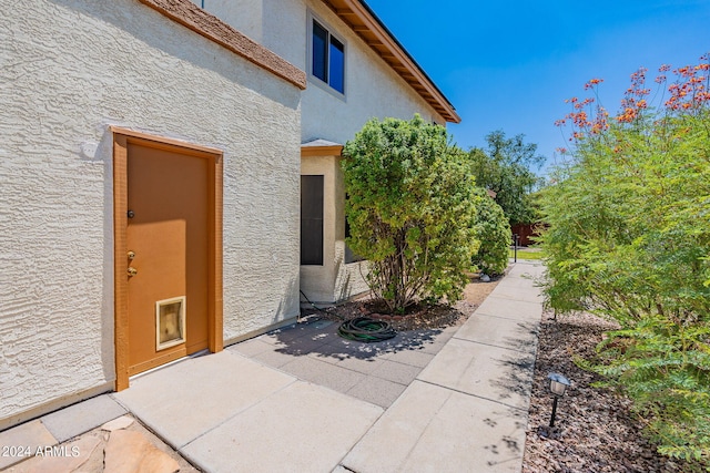 doorway to property featuring a patio and stucco siding