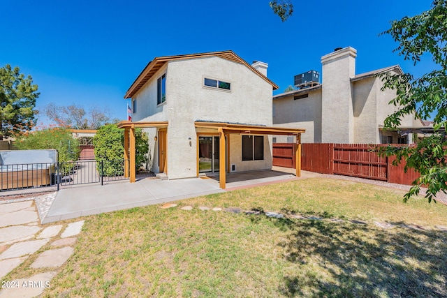 rear view of house with fence private yard, stucco siding, a lawn, and a patio