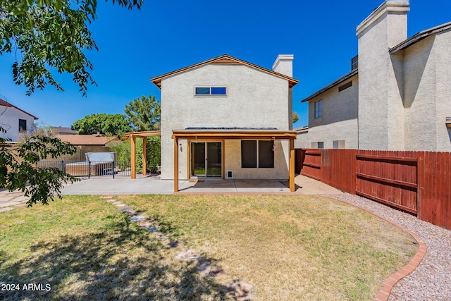 back of house featuring a fenced backyard, a chimney, a yard, a patio area, and stucco siding