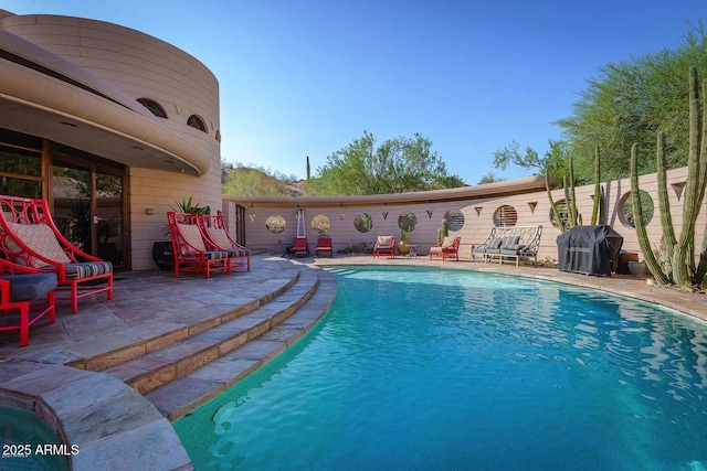 view of swimming pool featuring a patio area and a grill