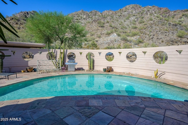 view of swimming pool featuring a patio area and a mountain view