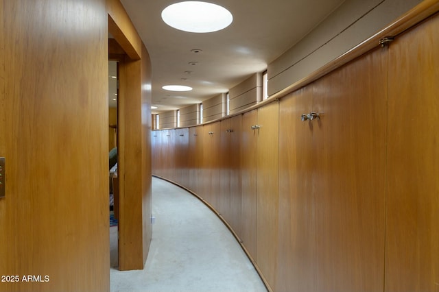 corridor with light carpet and wood walls