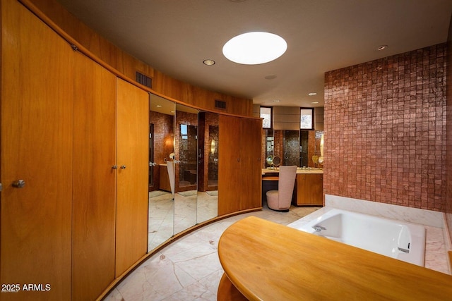 bathroom with a bathing tub and vanity