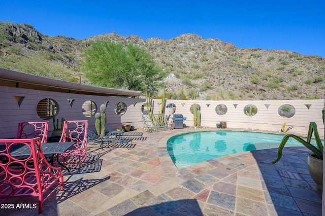 view of pool with a mountain view and a patio