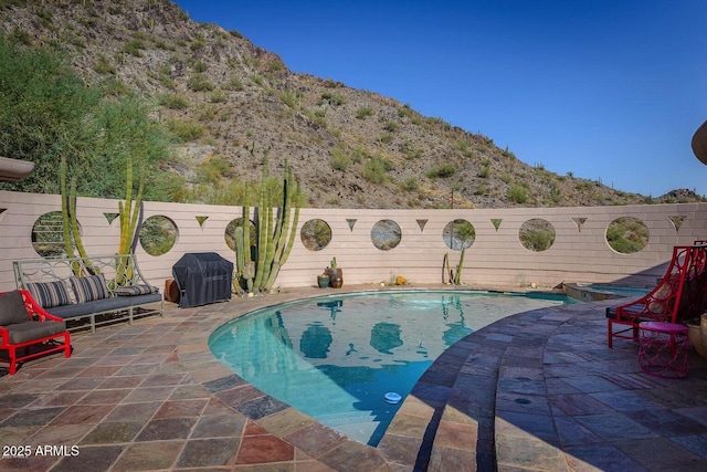 view of swimming pool featuring a patio area, area for grilling, and a mountain view