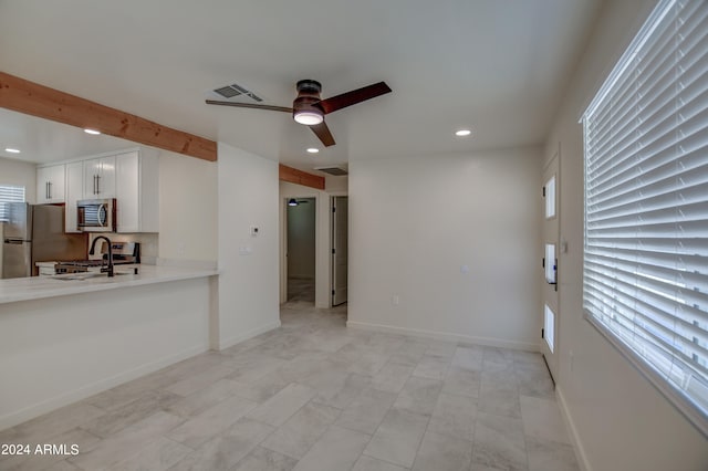 unfurnished living room featuring sink, ceiling fan, light tile floors, and plenty of natural light