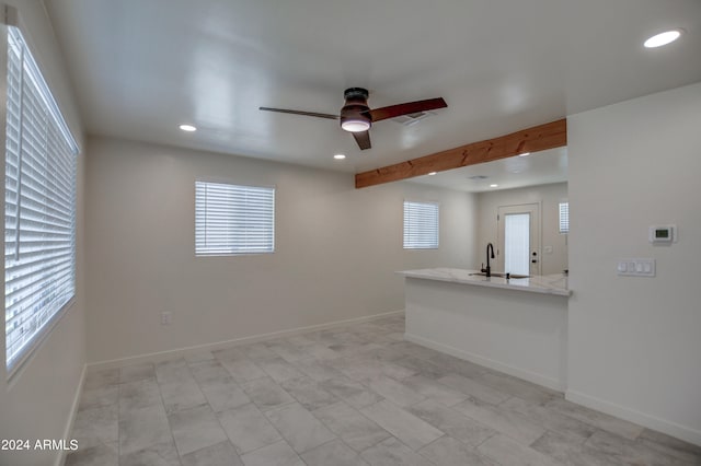 spare room featuring sink, ceiling fan, light tile floors, and beam ceiling