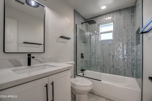 full bathroom with tiled shower / bath combo, vanity, and toilet