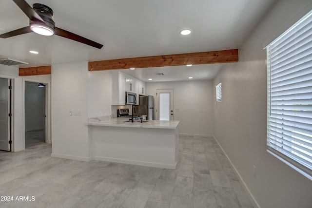 kitchen featuring a wealth of natural light, ceiling fan, kitchen peninsula, and white cabinetry