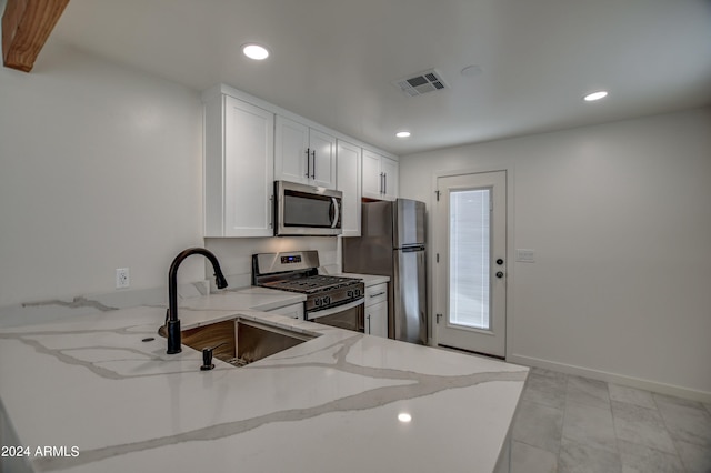 kitchen featuring light tile flooring, white cabinetry, appliances with stainless steel finishes, sink, and light stone counters